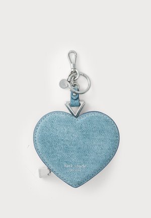 Hjärtfomad nyckelringplånbok i ljusblå denimtextur, med silverfärgade detaljer, dragkedjestängning och logotypdetalj på framsidan.