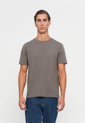 Grå bomull T-skjorte med korte ermer, rund nakke og en liten logo på brystet. Kombinert med blå denim jeans.