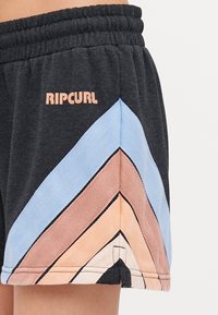 Pantalones cortos negros para mujer con una cinturilla acanalada, decorados con un patrón en zigzag en azul, beige y terracota. Logo en la parte delantera en rosa claro.