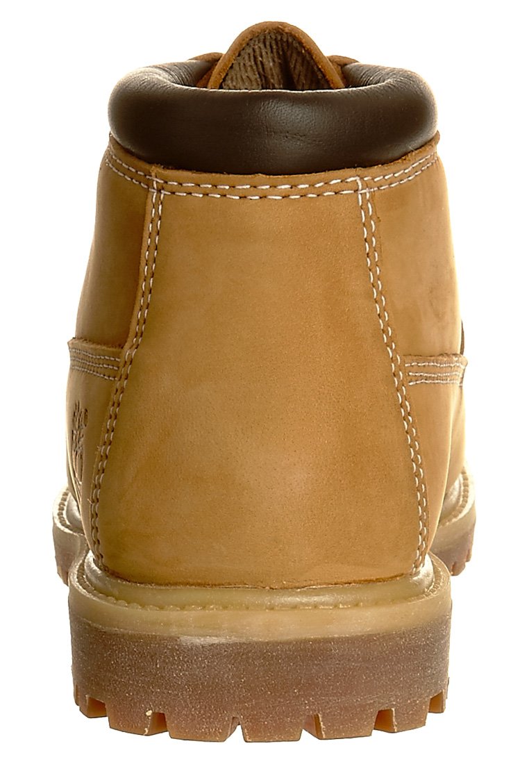 Bottine en cuir tan avec un col rembourré marron, des coutures blanches et une semelle en caoutchouc robuste. Présente une finition texturée et un fond profilé.