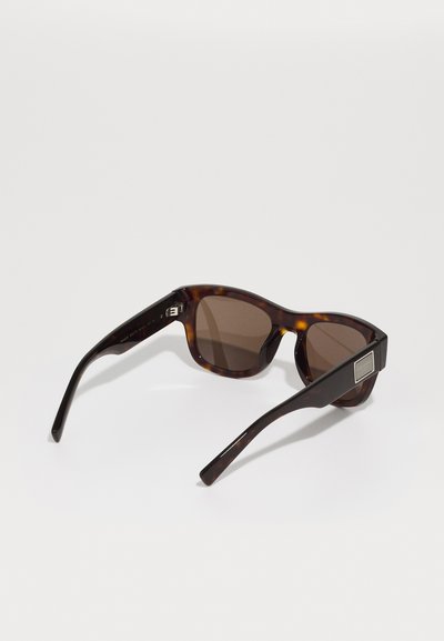 Tortoiseshell sunglasses with brown lenses, rectangular shape, and sleek black accents on temples. Includes a small metal detail on the side.