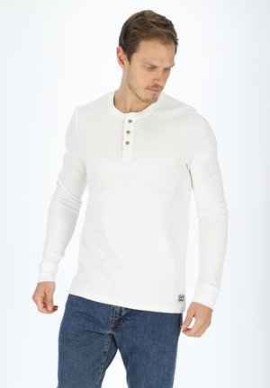 Weißes Langarm-Henley-Shirt aus geripptem Stoff, mit Rundhalsausschnitt, einer Knopfleiste mit drei Knöpfen und einem Logo-Tag am unteren Ende.
