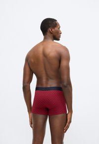 Rot karierte Boxershorts mit einem marineblauen Bund, entworfen für eine enge Passform, mit glatter Textur und mittlerer Oberschenkellänge.
