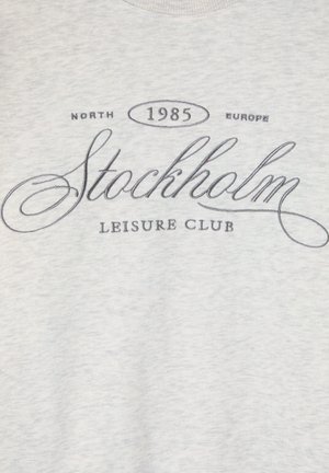 Felpa grigia con un grafiche frontale che presenta il testo "Stockholm Leisure Club," insieme a "North" e "1985" in carattere nero.