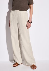 Lätta, vida linbyxor i krämfärgad med en texturerad yta. Har sidofickor och en bekväm elastisk midja.