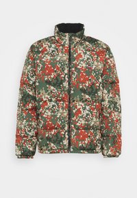 Doudoune à motif camouflage avec des couleurs vert, rouge, beige et noir, un col montant et une fermeture éclair frontale.