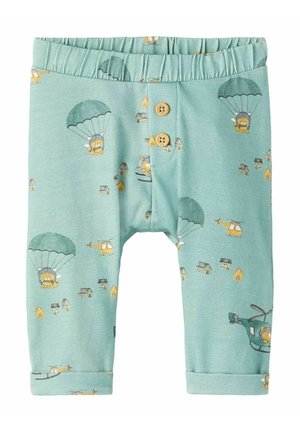 Pantalon bébé bleu sarcelle clair avec taille élastique, deux boutons en bois, et imprimés de lions en parachute, hélicoptères et petites maisons.