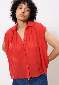 Rotes, leichtes Hemd mit Knöpfen, Kragen, kurzen Ärmeln und lockerer Passform. Hat eine zerknitterte Textur und einen geraden Saum.