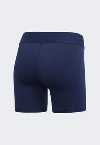 Námornícke modré športové šortky s hladkou textúrou a širokým elastickým pásom; majú priliehavý strih a čisté švy.