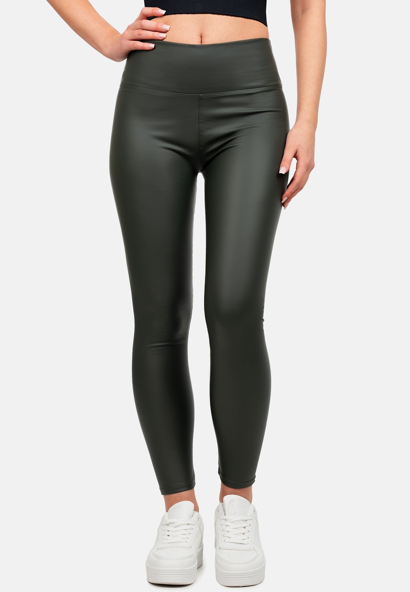 Leggings a vita alta di colore verde oliva con una texture liscia e elastica, abbinate a sneakers bianche. Design aderente senza cuciture visibili.