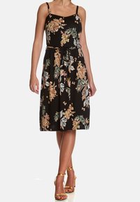Květinové černé šaty s tenkými ramínky, přiléhavým korzetem a páskem v pase. Mají jasné květiny a listy, sahající do délky po střed lýtek.