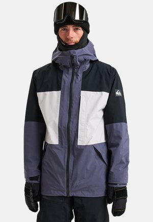 Skijacke mit einer Kombination aus lila, schwarz und weißen Paneelen, mit einem Reißverschluss, hohem Kragen und verstellbare Kapuze. Strukturiertes Material und Taschen.