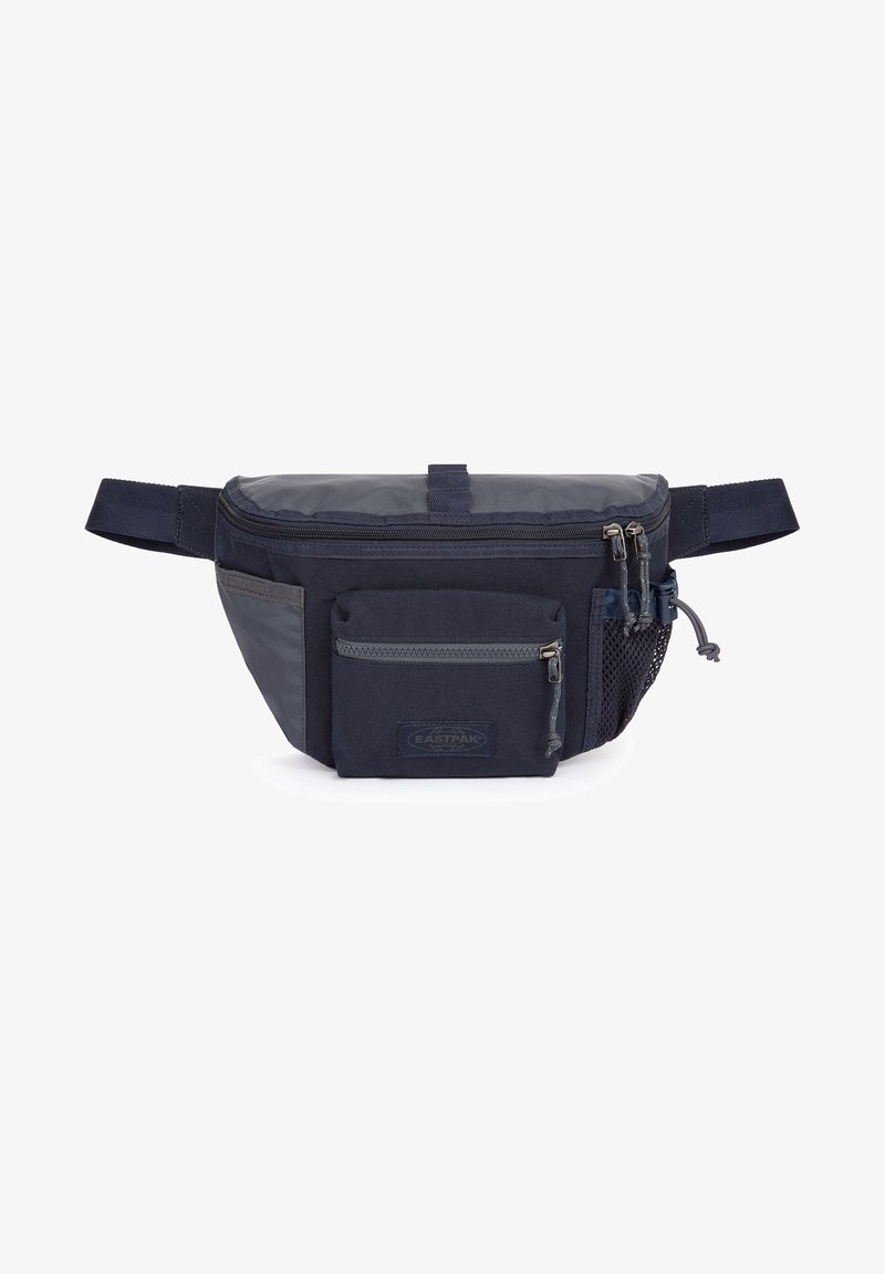 Sac banane Eastpak bleu marine avec une poche zippée à l'avant, une poche en mesh latérale, une fermeture éclair supérieure et une sangle réglable sur fond blanc.