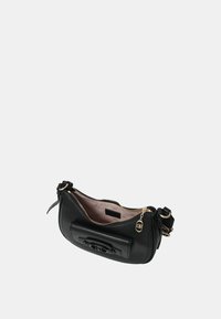 Borsa crossbody in pelle nera con hardware dorato, chiusura con zip e un'esterno testurizzato. L'interno presenta un motivo chiaro e un'etichetta con il logo.