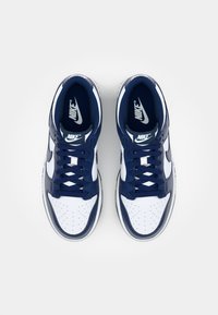 Navy blue and white leather sneakers featuring a perforated toe box, laces, and a prominent Nike logo on the tongue and side.