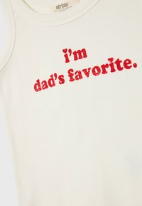 Hvid ribbet tanktop med teksten "jeg er fars favorit" i fed, rød skrift. Stoffet ser blødt ud med en let glans.