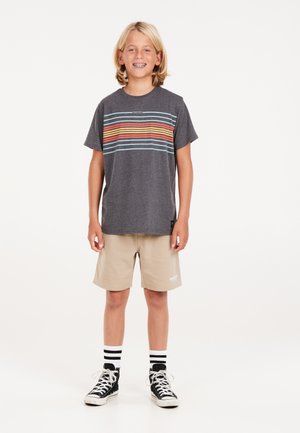 T-shirt grise avec des rayures colorées horizontales, shorts beiges, baskets montantes noires et chaussettes blanches rayées. Design simple, coupe décontractée.