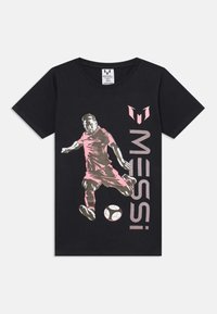 Musta T-paita, jossa on grafiikka pinkissä pelaajasta potkaisemassa jalkapalloa, ja "MESSI" -teksti painettuna vaaleanpunaisena sivulle.