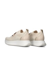 Beige knit sneakers feature a rounded shape with a textured surface, soft accents, and a white rubber sole. Elastic closure for easy wear.