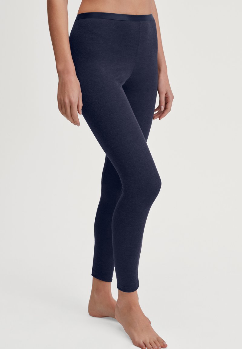 Donkerblauwe legging gemaakt van zachte stof met een gladde textuur. Ze hebben een aansluitende pasvorm en een simpele, elastische tailleband.