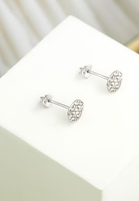 Orecchini a perno in argento di forma circolare, con un motivo geometrico e una finitura lucida. Inclusi i ganci per un indossamento sicuro.