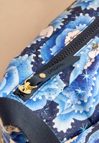 Borsa a motivo blu e navy con fiori e stelle, dotata di una cerniera dorata e un tirante navy. Tessuto texturizzato con una finitura liscia.