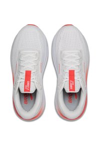 Zapatillas de correr blancas con una parte superior de malla, superficie texturizada, acentos rojos en los cordones y el talón, y una suela acolchada.
