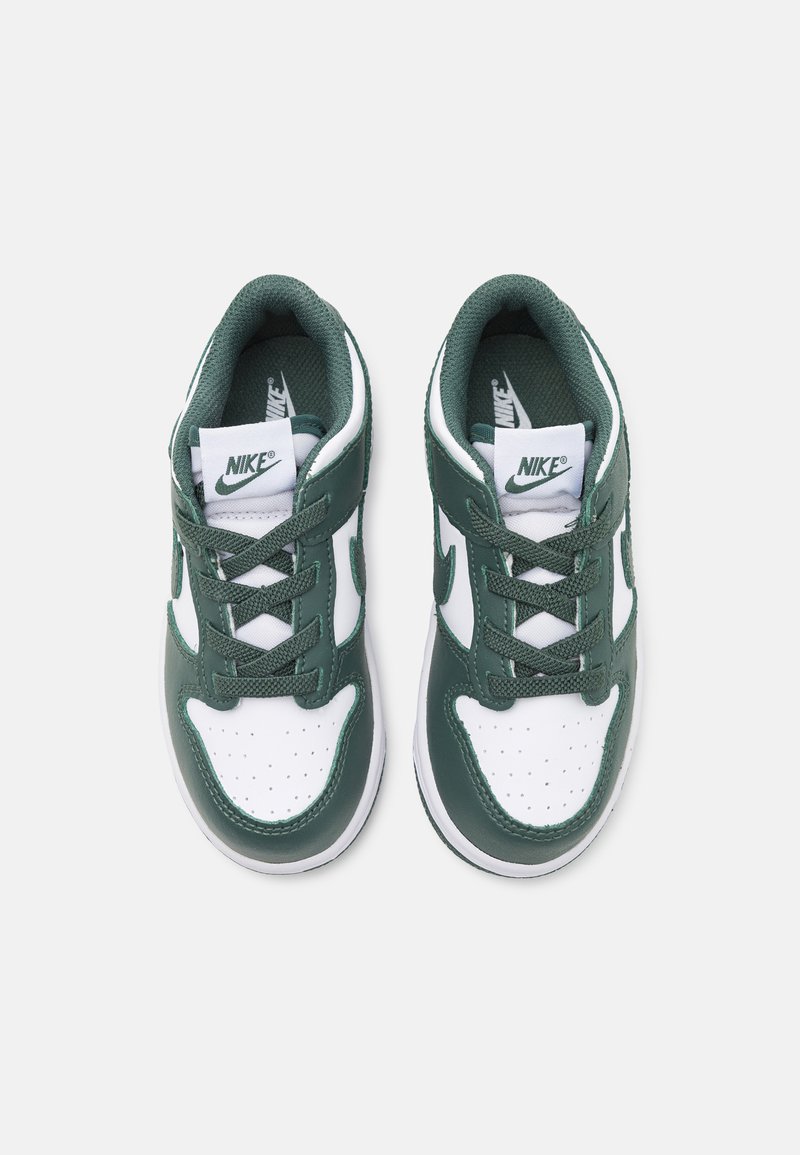 Par de zapatillas Nike blancas y verde oscuro con cordones, con el logo visible en la lengüeta y en la plantilla, mostradas desde arriba sobre un fondo liso.