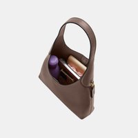 Sac à main en cuir marron avec poignée supérieure contenant une bouteille d'eau violette, un smartphone avec étui, un portefeuille doré métallisé et un chouchou rose.