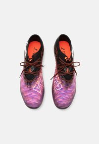 Chaussures de sport noires et violettes avec des rayures dégradées et des accents réfléchissants. Intérieur orange et lacets noirs. Logo de la marque sur le côté.