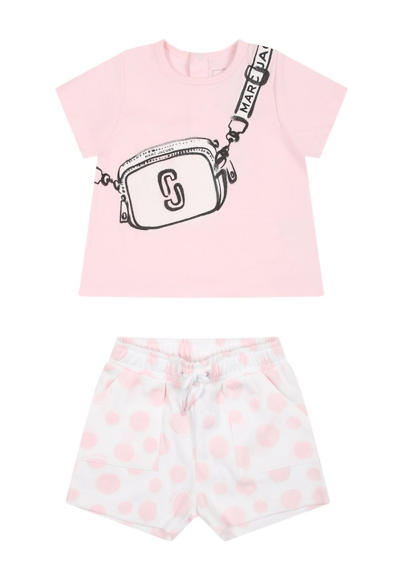 Camicia rosa a maniche corte con una grafica di una borsa e dettagli neri, abbinata a pantaloni corti bianchi con pois rosa e vita con coulisse.