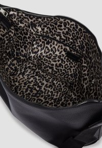 Schwarze Textur-Handtasche mit Innenfutter aus Leopardenmuster und einer Innentasche mit Reißverschluss, von oben geöffnet gezeigt.