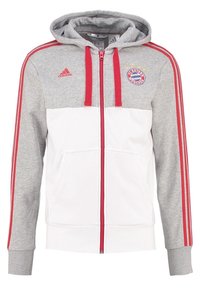 Haut de hoodie zippé gris et blanc avec des accents rouges. Comprend une poche kangourou, des poignets côtelés et un logo de Bayern Munich brodé sur la poitrine.