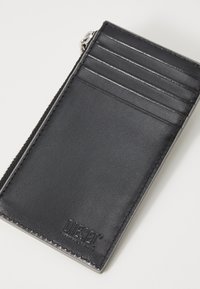 Black leather cardholder with multiple card slots and a zip compartment. Features embossed logo and smooth texture with durable stitching.