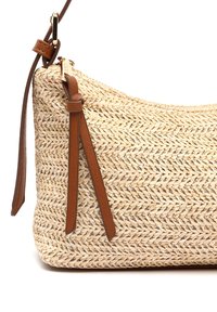 Kudottu olkalaukku kaarevalla muotoilulla, jossa on ruskea nahkahihna ja solmukohta. Rikkaita pintarakenteita luonnollisessa värimaailmassa.