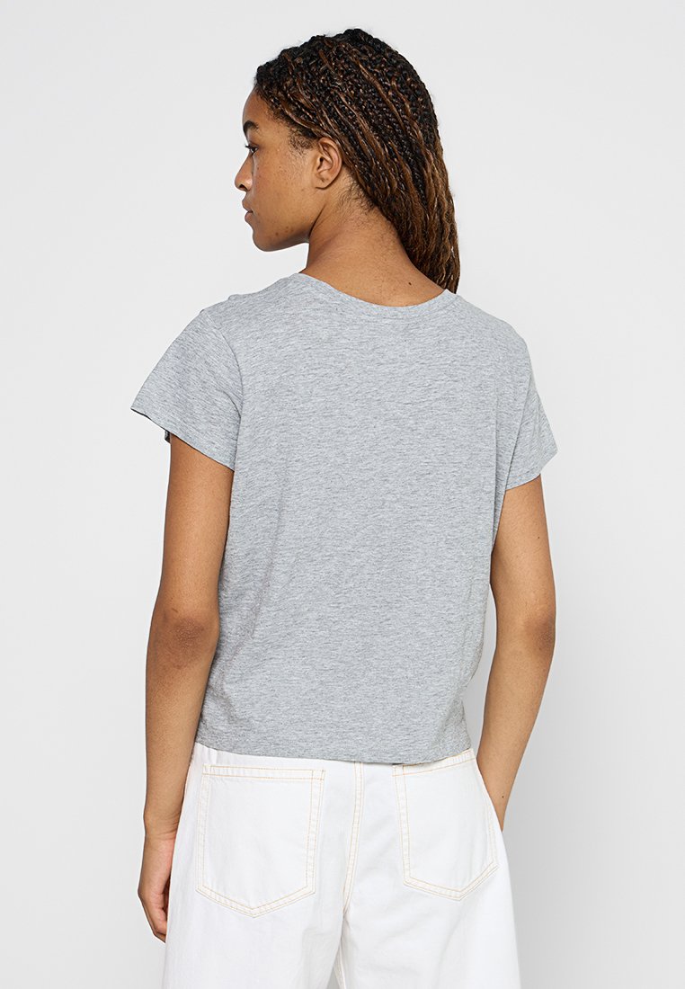 Graues T-Shirt mit kurzen Ärmeln und rundem Ausschnitt, aus leichtem Stoff und mit lockerem Schnitt, von hinten vor einem schlichten Hintergrund gezeigt.