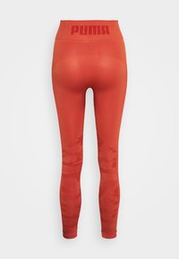 Leggings rossi con vita alta, logo "PUMA", parte superiore in rete testurizzata e un sottile motivo camouflage sulle gambe inferiori.