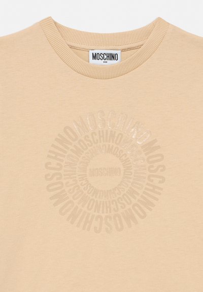 Sudadera beige con cuello redondo con patrón de logo circular de Moschino en estampado beige ligeramente brillante en el pecho, con una etiqueta Moschino Kid en el interior del cuello.