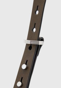 Brązowy skórzany pasek do zegarka z srebrnymi ćwiekami i metalową klamrą z wygrawerowanym napisem "ALLSAINTS". Gładka tekstura i wyraźne perforacje.