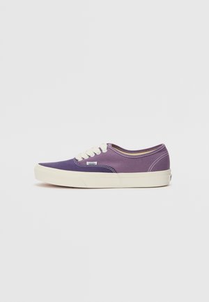 Purple canvas sneaker with white laces and rubber sole. Features a rounded toe and contrasting stitching along the sides.