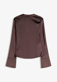 Blusa in raso marrone con design aderente, maniche lunghe e scollatura rotonda. La texture liscia e l'orlo curvo sono caratteristiche distintive.