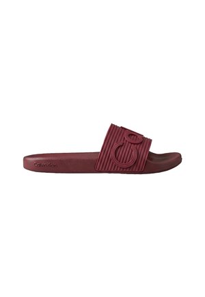Bordowe klapki typu slide marki Calvin Klein z teksturowanym paskiem z wypukłym logo 'CK' i profilowaną wkładką na białym tle.