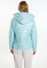 Giacca puffer color turchese chiaro con finitura lucida, cappuccio e motivo a chevron, dotata di polsini elasticizzati e un design perfettamente integrato.