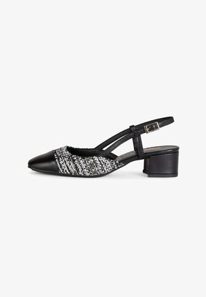 Zapato de tira trasera negro con puntera puntiaguda, tacón ancho y panel superior tejido en relieve blanco y negro.