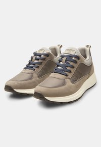 Sneaker atletiche beige e grigie realizzate in suede e mesh, con punta tonda e suola in gomma testurizzata con accenti scuri a contrasto.