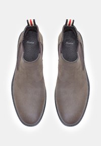 Botas de ante marrón hasta el tobillo con paneles laterales elásticos, una suela negra texturizada y una pestaña de tira en el talón de rayas rojas, blancas y marinas.