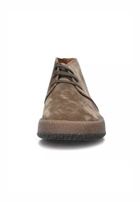 Scarpa in suede marrone con lacci, dotata di una suola in gomma texturizzata, caratterizzata da un design elegante e da cuciture minimali lungo i bordi.