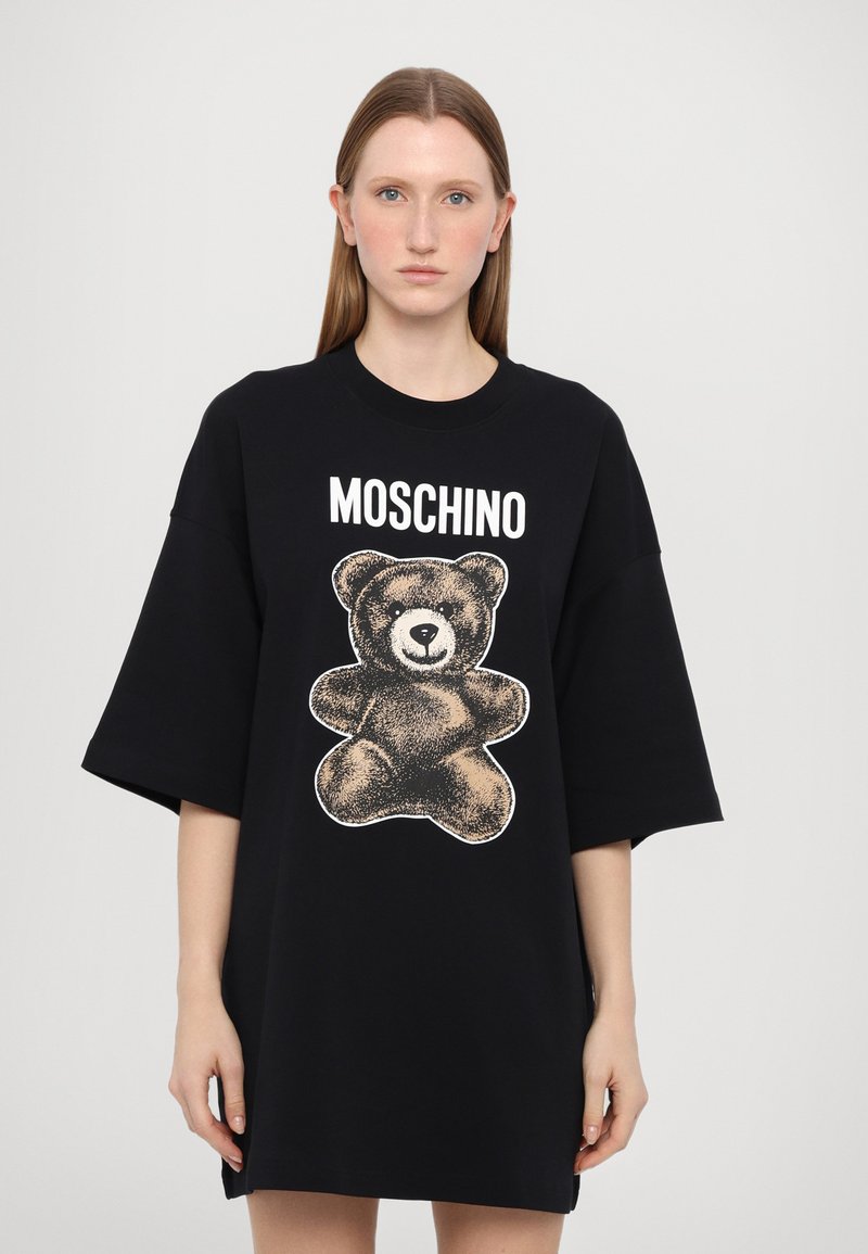 Svart bomullsoverstora t-shirt med en stor teddybjörnsgrafik i brunt med vit kontur och "Moschino" text ovanför. Korta ärmar.