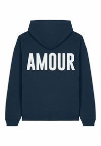 Tumši zili kapuci džemperis, izgatavots no kokvilnas, ar lielu balto tekstu "AMOUR" muguras daļā, ribām aprocēs un apakšmalā. Gluda auduma tekstūra.