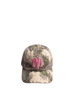 Femme portant une casquette camouflage avec un lettrage "NY" brodé rose, des boucles d'oreilles créoles dorées et une veste rose texturée par-dessus un haut assorti.